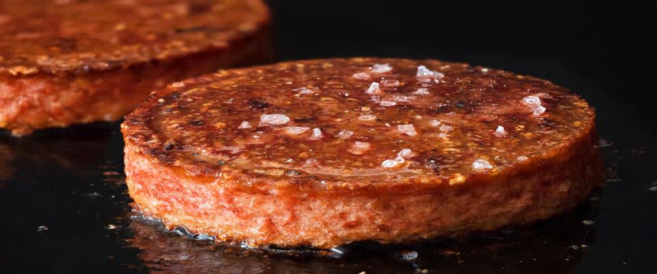 plant-based meat patties cooking on grill