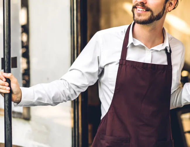 Restaurant employee holding door handle