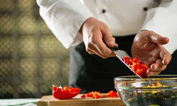 Chef chopping vegetables to make salad