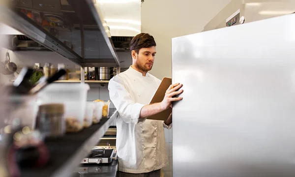 Chef checking cold storage freezer in kitchen