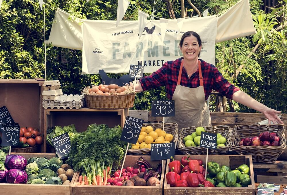 Greengrocer selling organic fresh agricultural product at farmers market