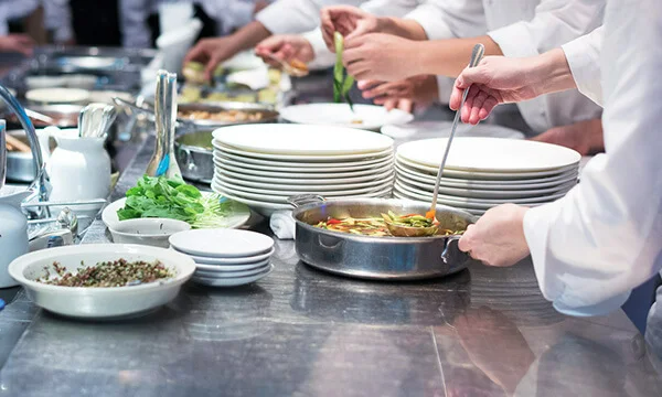 Chefs plating food in kitchen