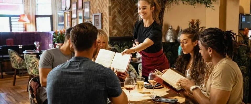 Waitress serving simple menu to table of customers