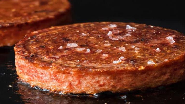 plant-based meat patties cooking on grill