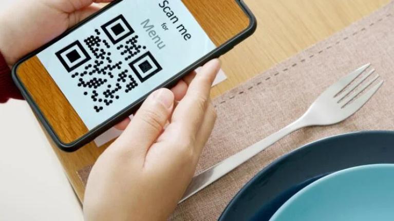 Customer scanning QR code menu with smartphone