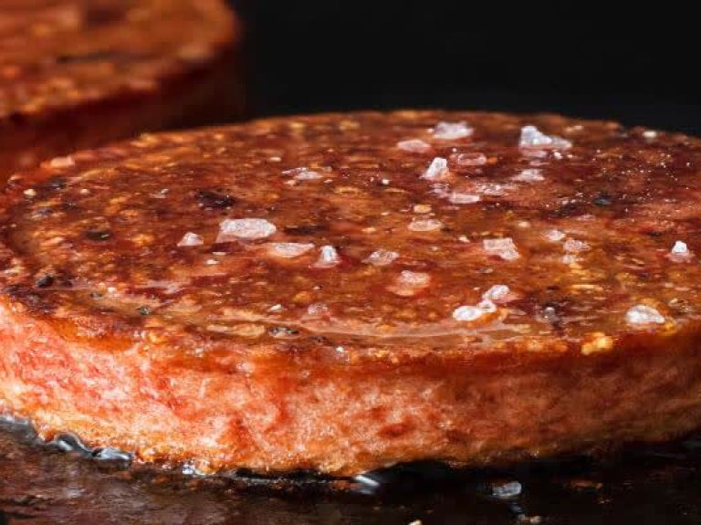 plant-based meat patties cooking on grill