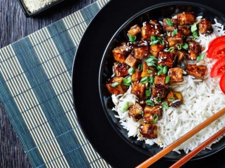 Teriyaki tofu with rice, green onion, and sliced tomato in bowl