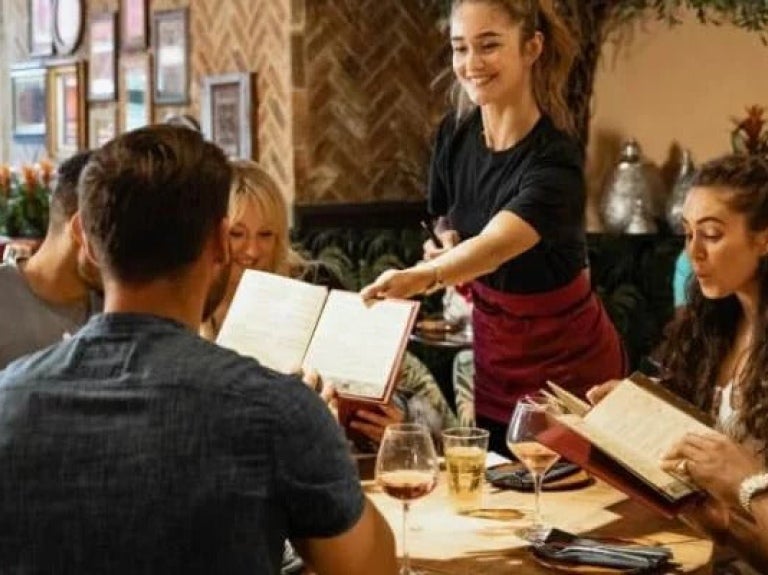 Waitress serving simple menu to table of customers